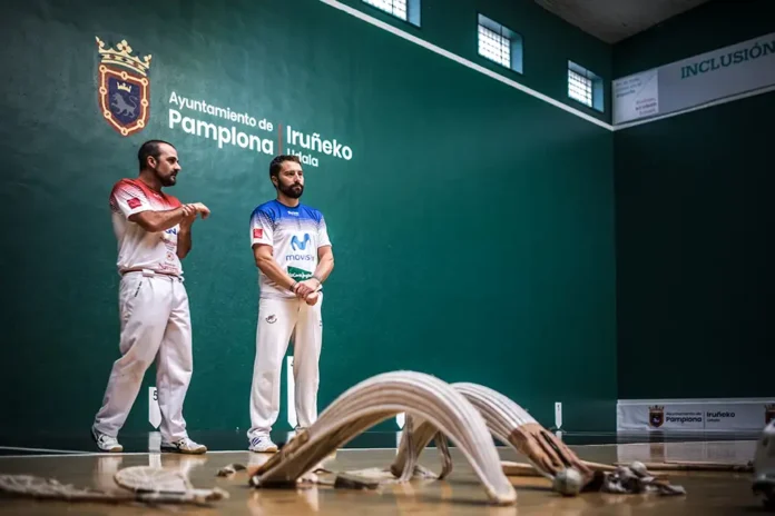 Pamplona capital mundial de la pelota vasca. Pareja de pelotaris y las cestas del juego de cesta punta o jai alai (en Euskera)