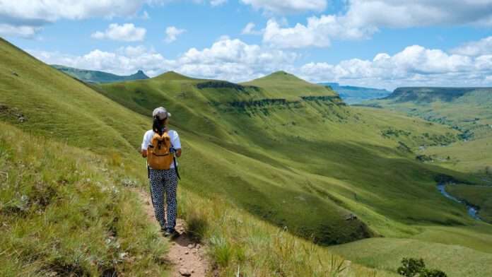 oung,Woman,Hiking,In,The,Mountains,,.drakensberg,Giant,Castle,South