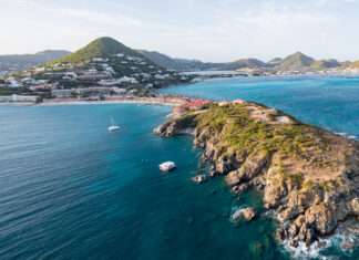 Saint-Martin: dos países, una isla y cinco formas de descubrirla Vista aérea de la costa de Sint Maarten, con una península rocosa rodeada por el mar Caribe